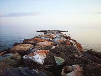 Rocks by sea against sky