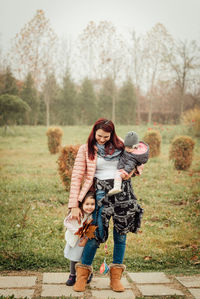 Young mom with two daughters playing and smiling in the park after the covid-19 quarantine