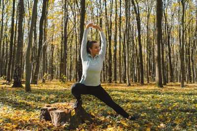 Girl doing fitness in nature on a sunny autumn forest