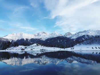 Scenic view of snowcapped mountains against cloudy sky