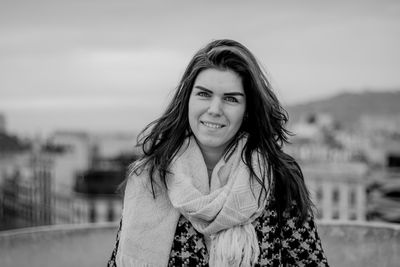 Portrait of smiling young woman standing against sky