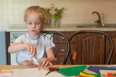 Girl looking away while sitting on table