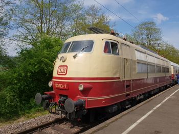 Train by railroad track against sky