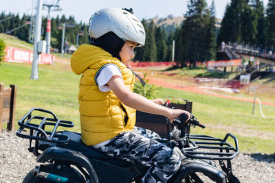 Side view of boy sitting on motorcycle