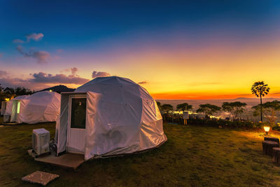 Tent on field against sky during sunset