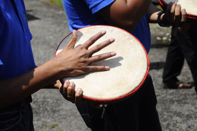 Midsection of man playing guitar on street