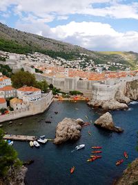 High angle view of townscape by sea against sky