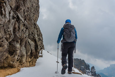 Rear view of walking on snow covered snow covered ridge