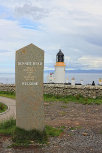 Lighthouse by sea against sky