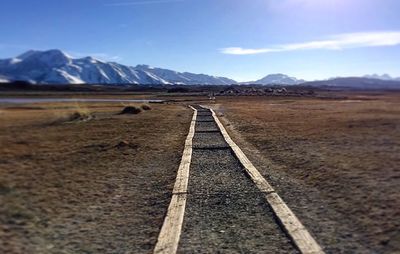 Scenic view of road by mountains against sky