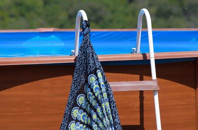 Pool ladder with hanging colored sarongs.