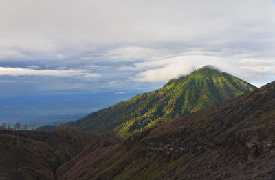 Scenic view of mountains against cloudy sky