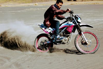 Man riding bicycle on sand