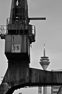 Low angle view of industrial building and rheinturm against sky