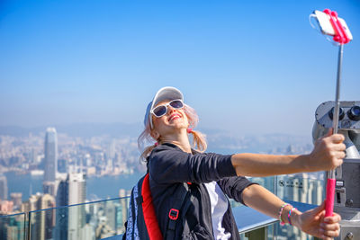 Woman taking selfie against sky on sunny day
