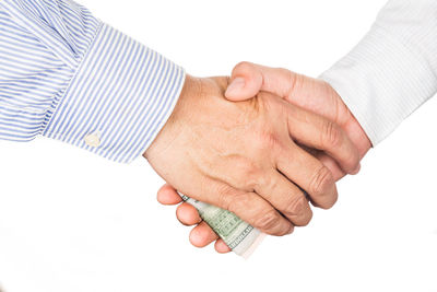 Close-up of man holding hands over white background