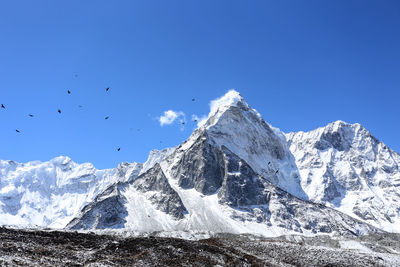 Scenic view of snowcapped mountains against clear blue sky