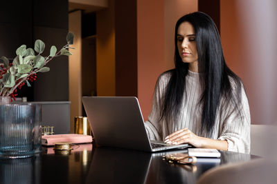 Young woman using laptop at table