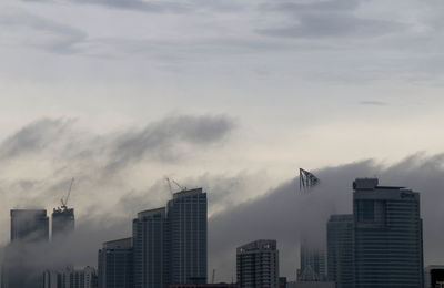 Low angle view of buildings in city against sky during sunset