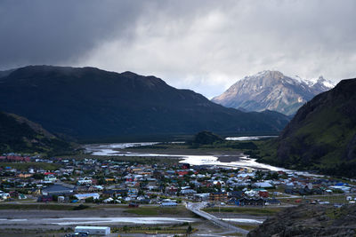 High angle view of townscape by mountains against sky
