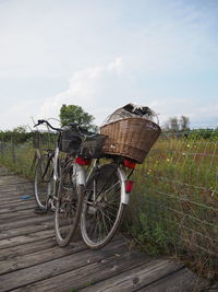 Bicycle in basket on field against sky