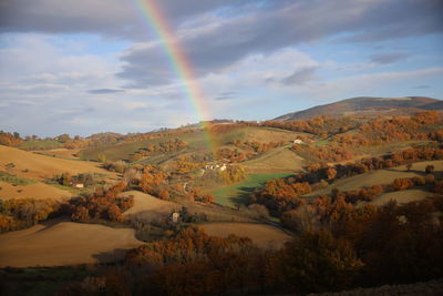 Scenic view of rainbow over landscape against sky