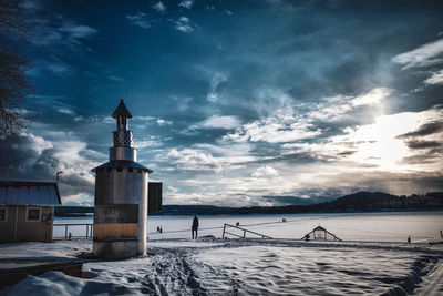 Lighthouse by sea against sky