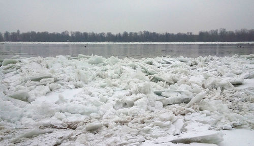 Frozen river against sky during winter