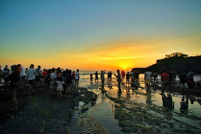 Group of people on beach during sunset