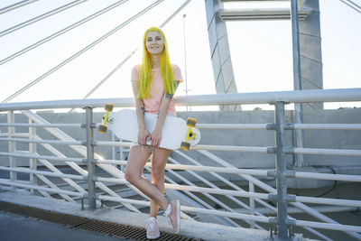 Portrait of woman standing against railing