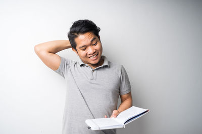 Young man looking away against white background