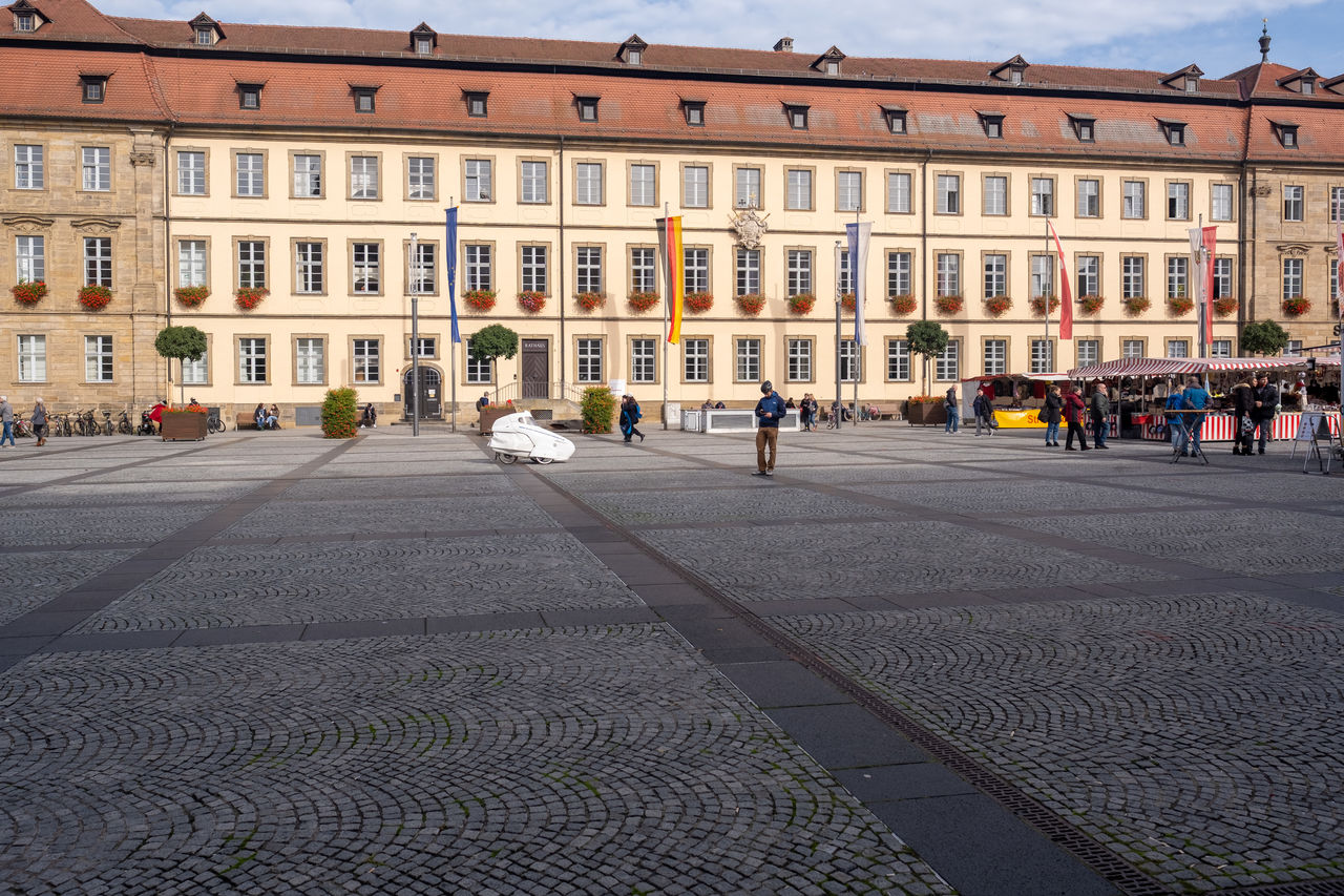 architecture, building exterior, built structure, city, town square, street, building, travel destinations, urban area, sky, nature, downtown, neighbourhood, plaza, history, the past, travel, city life, tourism, road, town, city street, group of people, transportation, day, outdoors, cityscape, facade, residential district, public space