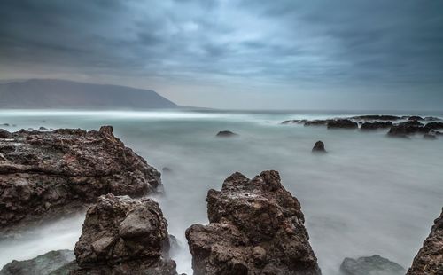 View of rocks in the sea near playa brava