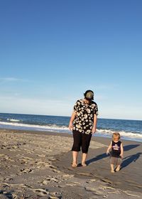 Full length of men on beach against sky