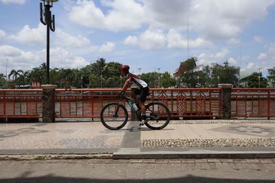 Man riding bicycle against sky