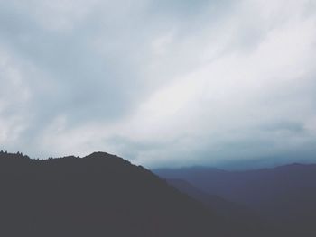 Scenic view of mountains against cloudy sky