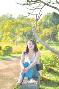 Portrait of young woman standing on field