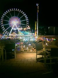 Illuminated ferris wheel at night