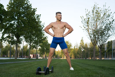 Shirtless man exercising on field