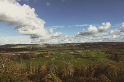 Scenic view of field against cloudy sky