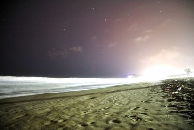 Scenic view of beach against sky at night