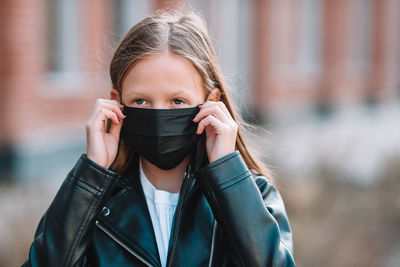 Portrait of a girl holding camera outdoors