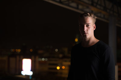 Portrait of young man standing at night