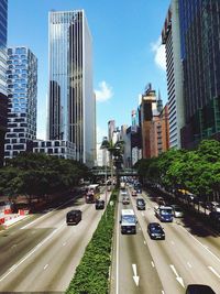 Traffic on city street by buildings against sky