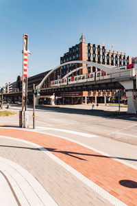 View of street and buildings against clear blue sky