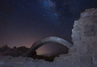 Rock formation on building against sky at night