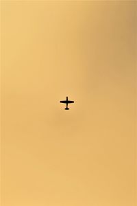 Low angle view of silhouette airplane against clear sky