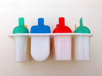 Close-up of multi colored bottles on white background