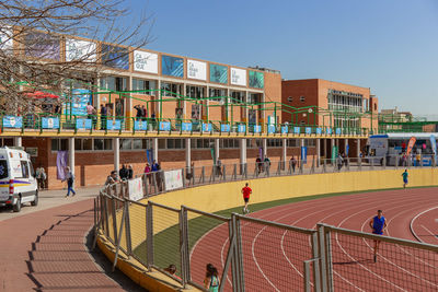 People playing outside building against sky