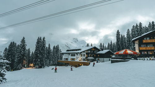 Snow covered houses and trees against sky